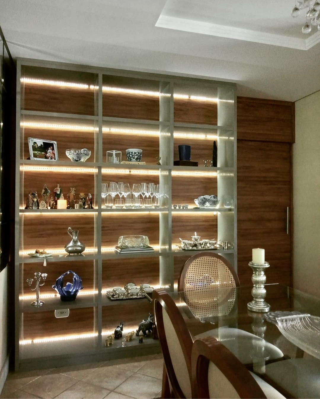 Cristaleira iluminada com porta de passagem — marcenaria personalizada de Juliana Balbim